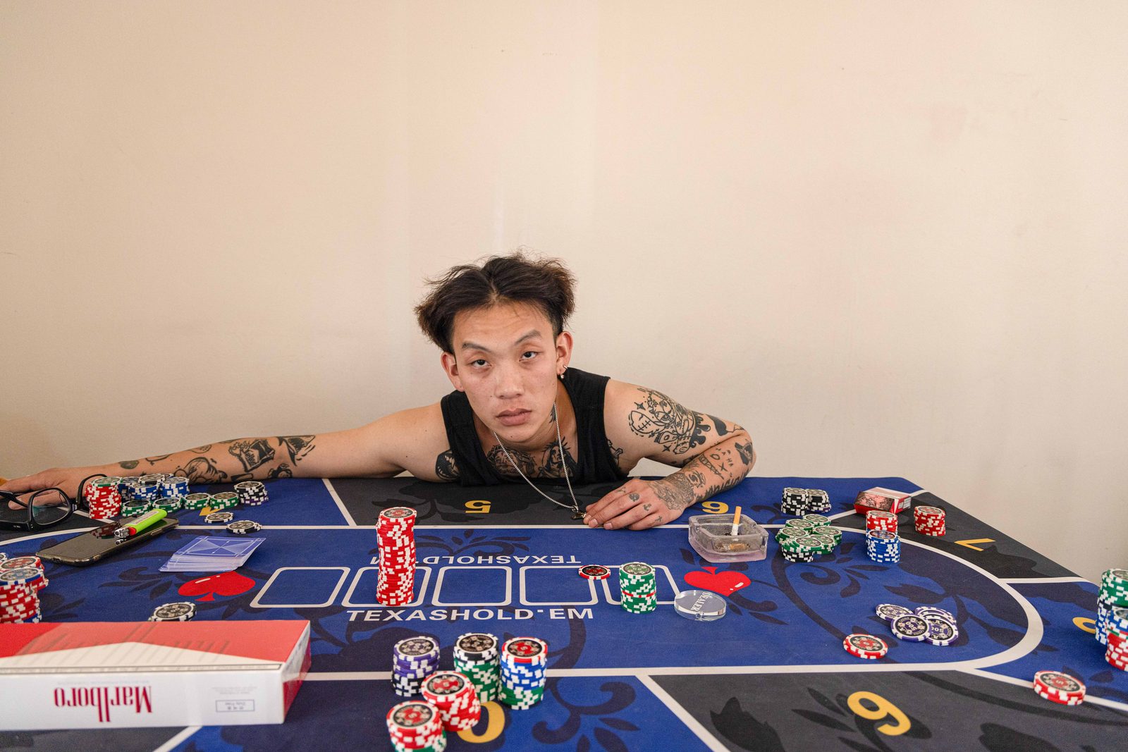 A man leaning over a poker table, chips and cards spread before him — Win or Lose