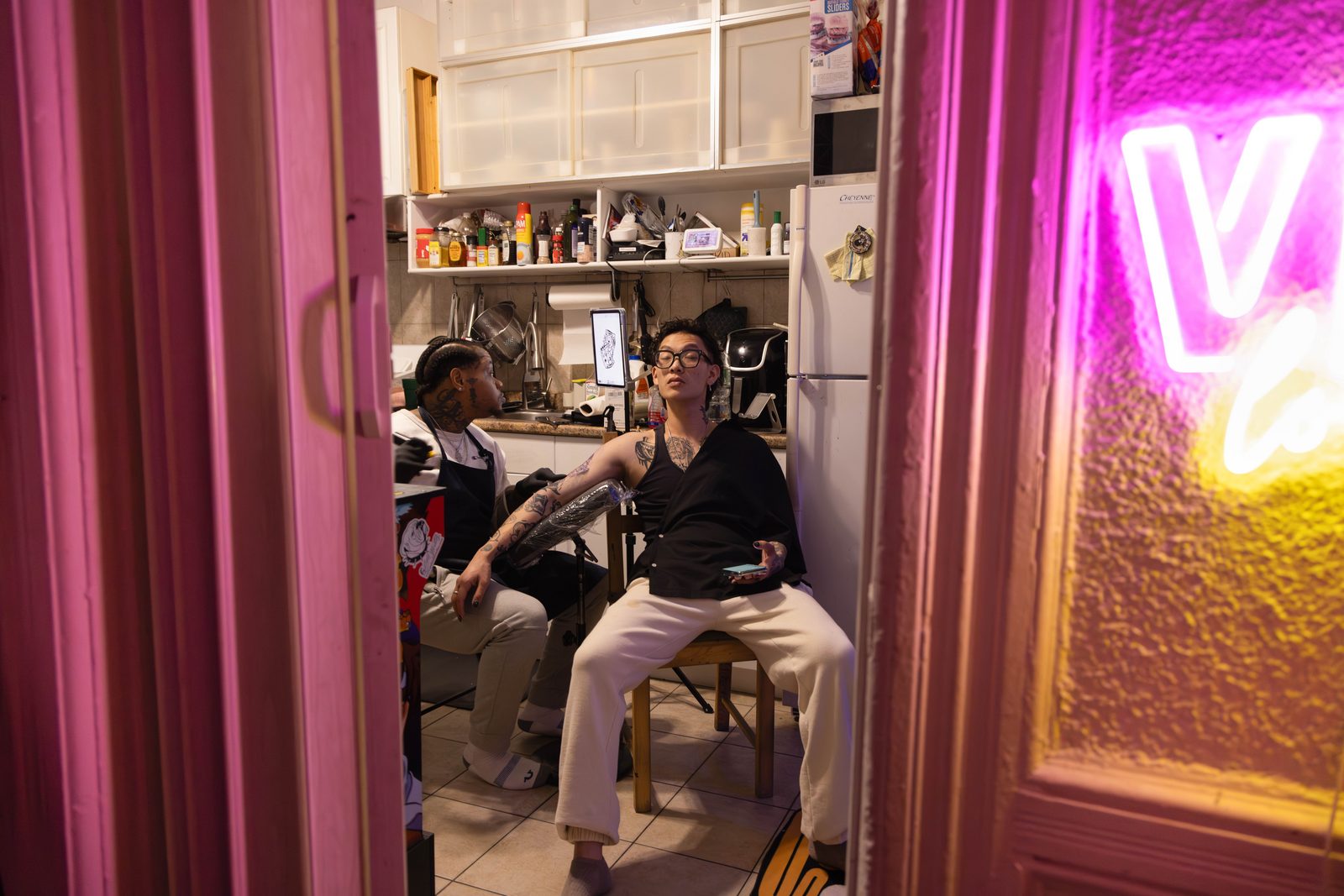A barbershop doorway lit by a pink neon sign, a man seated inside — Win or Lose