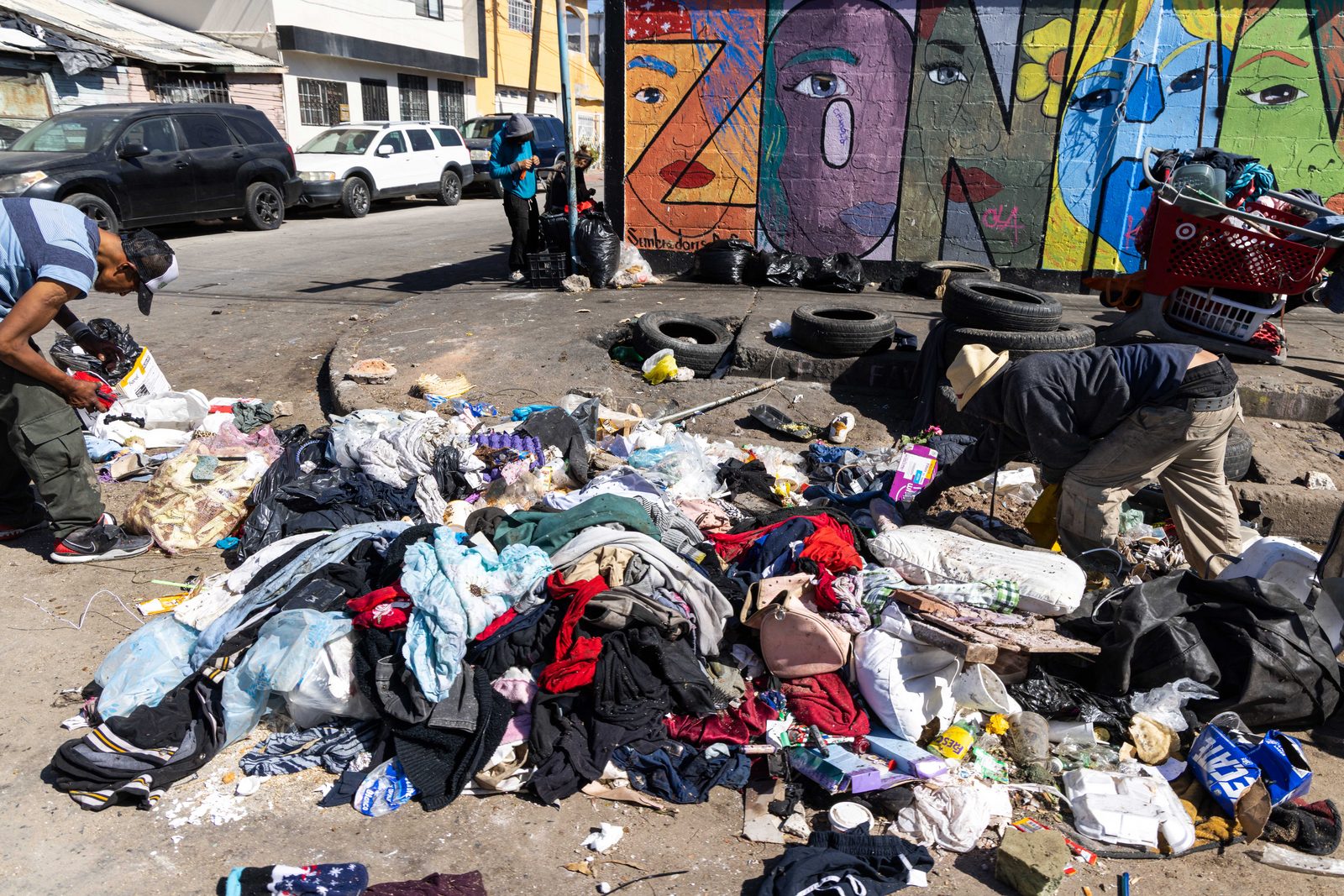 A sprawling pile of discarded clothes and belongings at an encampment — The Liminal Innocence