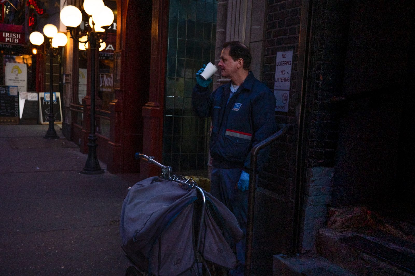 People on a sidewalk at night, seen past a foreground figure — New York